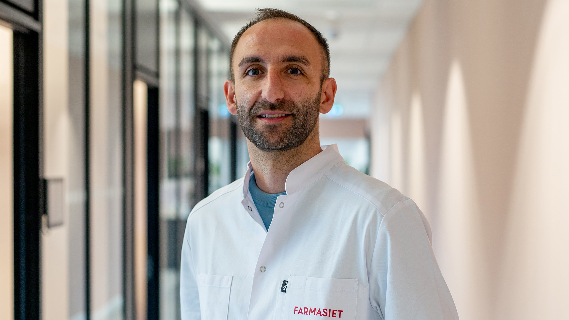 Bilde av en smilende mannlig farmasøyt